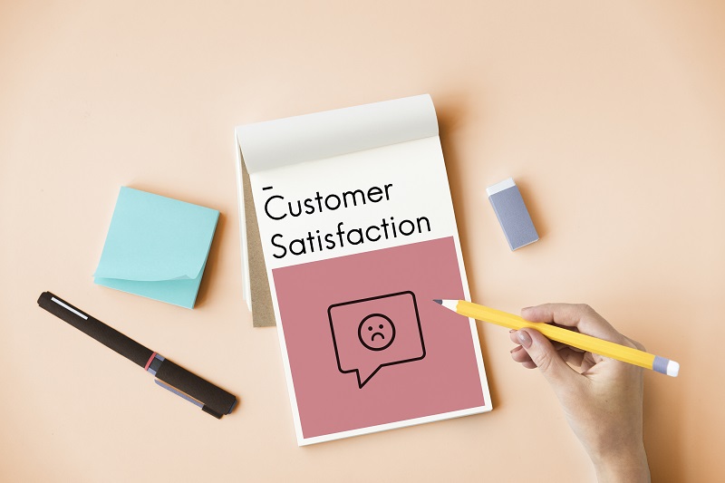one notepad on pink background there written on customer satisfaction